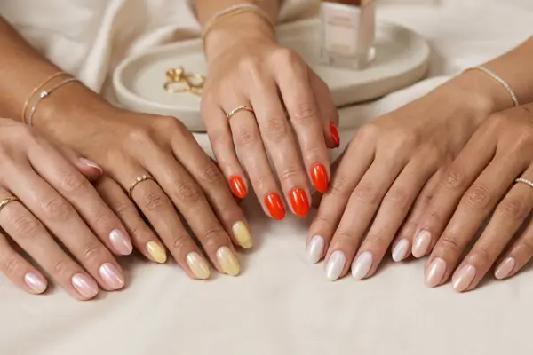 Mãos femininas com unhas elegantes em tons suaves e acabamento perolado representando as tendências de unhas para 2026.